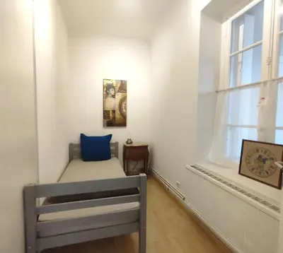 a small bedroom with a bed and a window at Appartement exceptionnel Bastide St Louis in Carcassonne