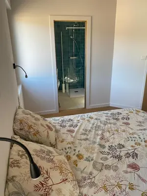 a bedroom with a bed and a lamp and a mirror at Gîte lumineux avec jardin, vue sur Peyrepertuse in Rouffiac-des-Corbières