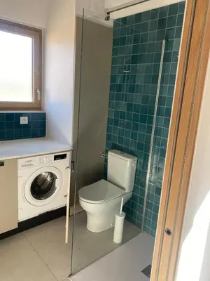 a bathroom with a toilet and a washing machine at Gîte lumineux avec jardin, vue sur Peyrepertuse in Rouffiac-des-Corbières