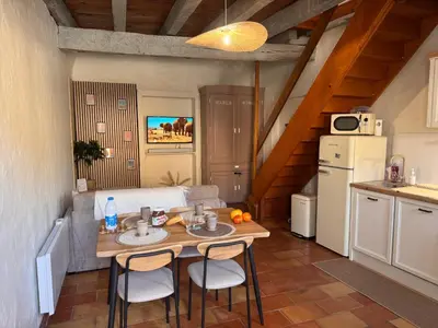 a kitchen with a table and chairs in a room at La Bohème - Cosy, calme & confort in Saint-Papoul