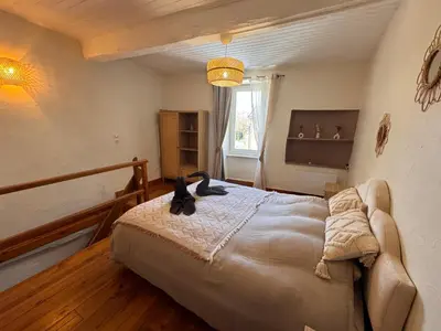 a bedroom with a bed with a cat on it at La Bohème - Cosy, calme & confort in Saint-Papoul