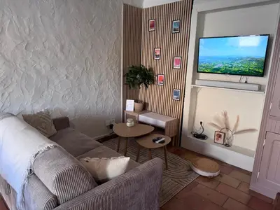 a living room with a couch and a flat screen tv at La Bohème - Cosy, calme & confort in Saint-Papoul