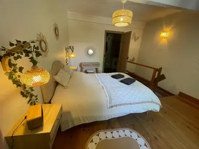 a bedroom with a large bed and a table at La Bohème - Cosy, calme & confort in Saint-Papoul