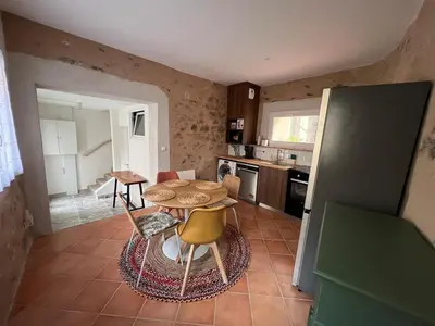 a kitchen with a table and chairs in a room at La bâtisse de Coustouge in Coustouge