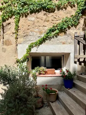 a window with potted plants in front of a building at La bâtisse de Coustouge in Coustouge