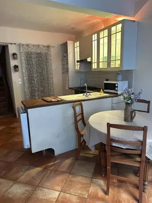 a kitchen with a sink and a table with chairs at Maison de charme à Bélesta in Bélesta