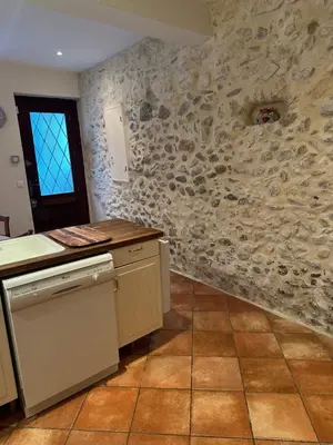 a kitchen with a stone wall at Maison de charme à Bélesta in Bélesta
