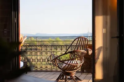 a chair sitting on a balcony with a view at Maison de charme et vue Imprenable à 180 degrés sur les vignes et Pyrénées in Paraza