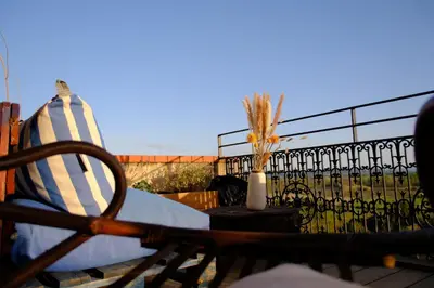 a patio with a chair and a vase on a balcony at Maison de charme et vue Imprenable à 180 degrés sur les vignes et Pyrénées in Paraza