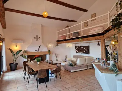 a living room with a table and a couch at Maison de charme et vue Imprenable à 180 degrés sur les vignes et Pyrénées in Paraza