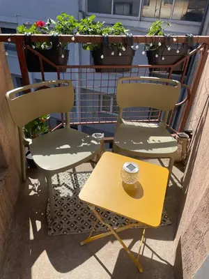 two chairs and a table on a balcony with plants at Stylish Apartment with Balcony - Very Central - Long Stays and Pets Welcome in Carcassonne