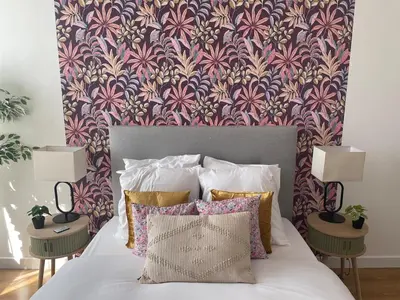 a bedroom with a bed with a floral wallpaper at Stylish Apartment with Balcony - Very Central - Long Stays and Pets Welcome in Carcassonne
