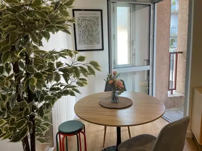 a dining room with a table and a plant at Stylish Apartment with Balcony - Very Central - Long Stays and Pets Welcome in Carcassonne