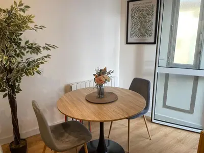 a dining room table with chairs and a vase with flowers at Stylish Apartment with Balcony - Very Central - Long Stays and Pets Welcome in Carcassonne
