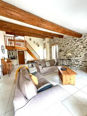 a living room with a couch and a table at Gîte au cœur d un caveau de dégustation de vin in Olonzac
