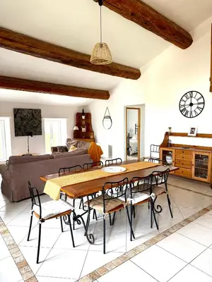 a living room with a table and chairs and a couch at Gîte au cœur d un caveau de dégustation de vin in Olonzac