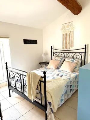 a bedroom with a black bed with pillows on it at Gîte au cœur d un caveau de dégustation de vin in Olonzac