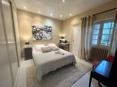 a bedroom with a white bed and a painting on the wall at Aux 138 in Carcassonne