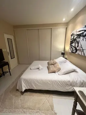a bedroom with a white bed and a painting on the wall at Aux 138 in Carcassonne