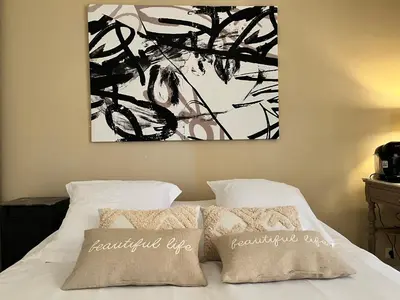 a bedroom with a bed with a painting on the wall at Aux 138 in Carcassonne