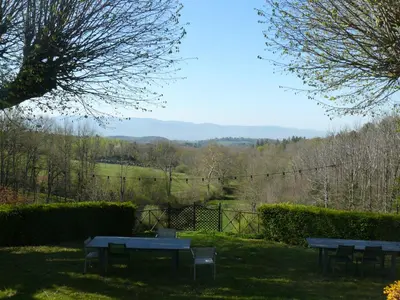 two picnic tables in the grass with a view at Villa Boulmia in Burlats