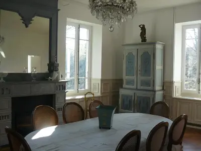 a dining room with a table and chairs and a chandelier at Villa Boulmia in Burlats