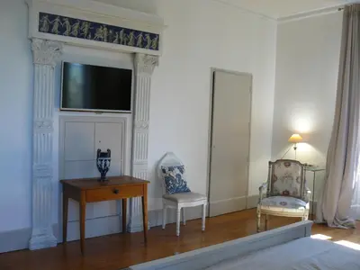 a room with two chairs and a table and a television at Villa Boulmia in Burlats