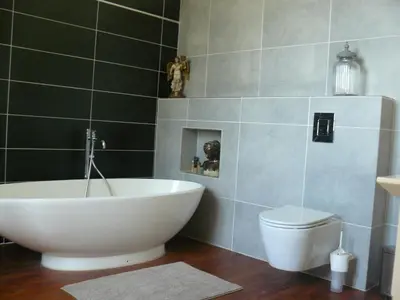 a bathroom with a white tub and a toilet at Villa Boulmia in Burlats