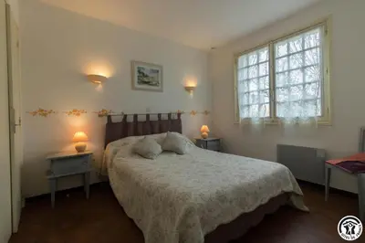a bedroom with a bed and two tables and a window at En vayssieres