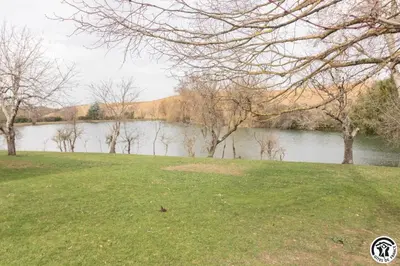 a grassy field next to a body of water at En vayssieres