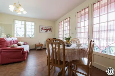 a living room with a table and a couch and windows at En vayssieres