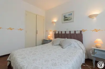 a bedroom with a bed with two night stands and two lamps at En vayssieres
