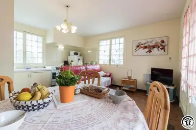 a kitchen and living room with a table with fruit on it at En vayssieres