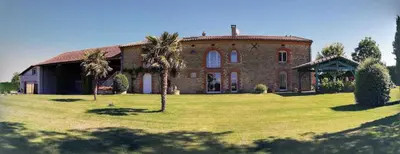 a large brick house with palm trees in the yard at Tournesols