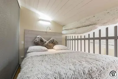 a bedroom with a large white bed with two pillows at Tournesols
