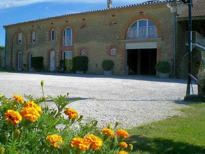a large brick building with orange flowers in front of it at Tournesols