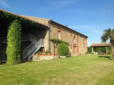 a large brick building with a palm tree next to a yard at Tournesols