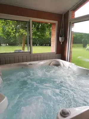 a jacuzzi tub in a room with two windows at Tournesols