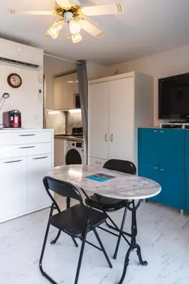 a kitchen with a table and chairs in a room at Le Nautilus in Gruissan