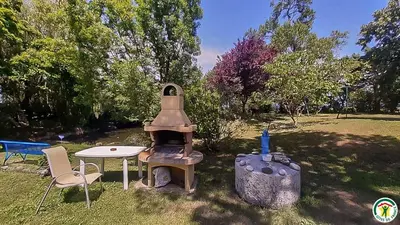 a outdoor oven with a table and chairs in a park at Perets petit in Montégut-Lauragais