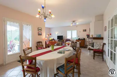 a dining room and living room with a table and chairs at Balanquier in Lagarde
