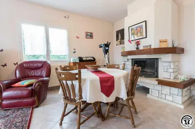 a dining room with a table and a fireplace at Balanquier in Lagarde