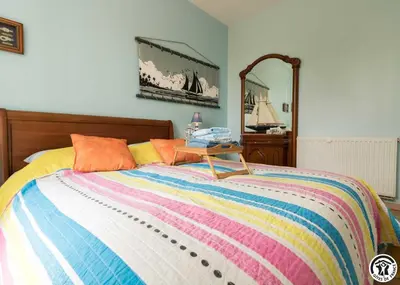 a bed with a colorful blanket and a table on it at Balanquier in Lagarde