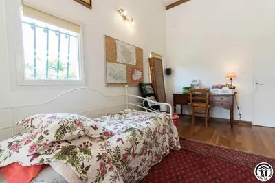 a bedroom with a bed and a desk and a window at Balanquier in Lagarde