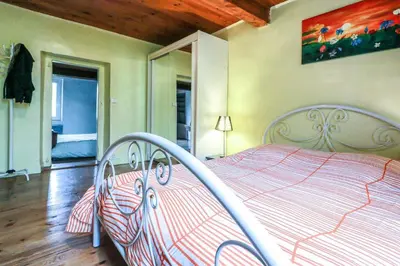 a bedroom with a bed with a red and white comforter at Les platanes in Aignes