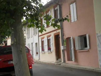 a red car parked in front of a building at Les platanes in Aignes