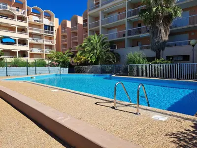 a swimming pool in front of a apartment building at Plage du grazel le thalassa in Gruissan