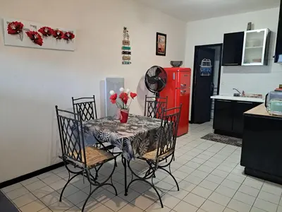 a kitchen with a table and chairs and a red refrigerator at Plage du grazel le thalassa in Gruissan