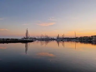 a marina with boats in the water at sunset at Plage du grazel le thalassa in Gruissan
