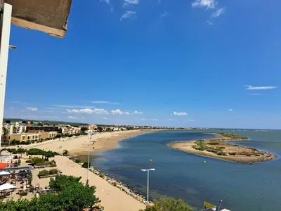 a view of a beach with buildings and the ocean at Plage du grazel le thalassa in Gruissan
